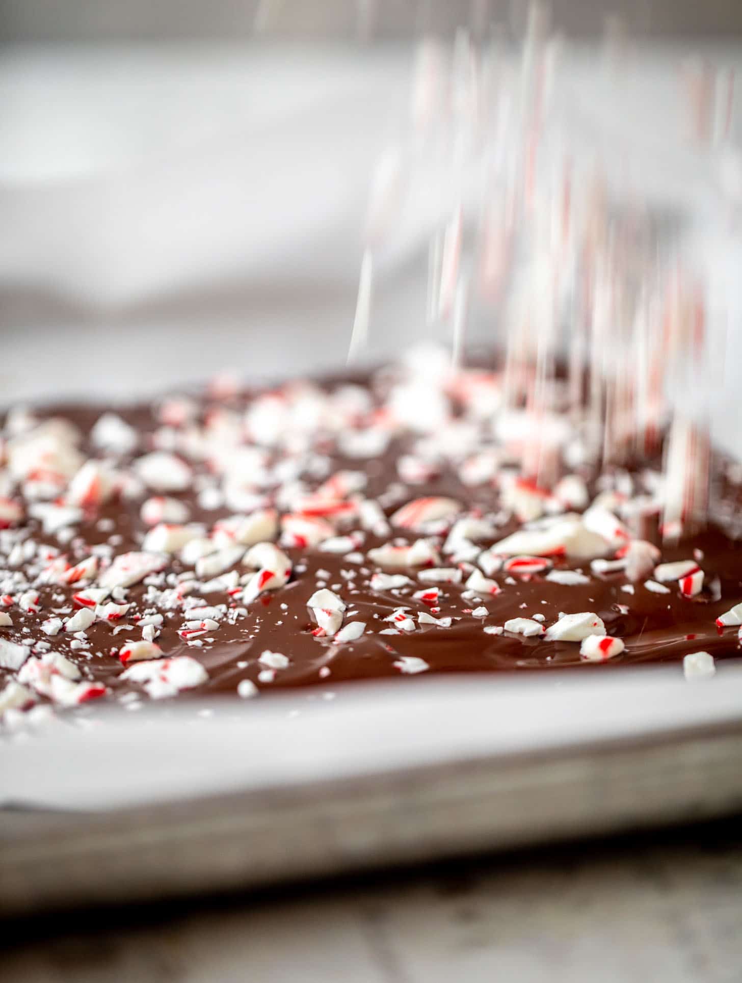 sprinkling crushed candy canes on chocolate