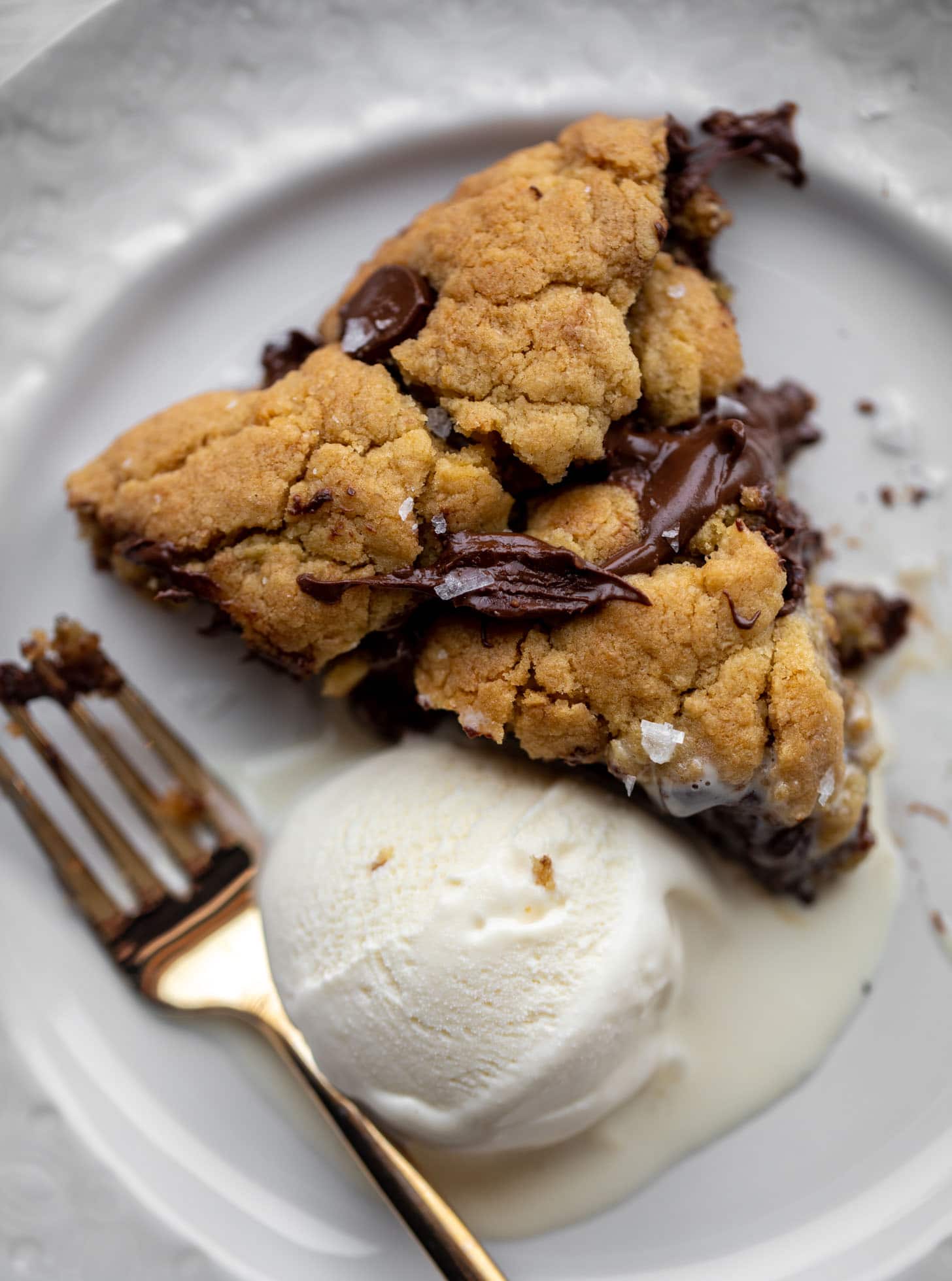 slice of chewy chocolate chip skillet cookie with ice cream