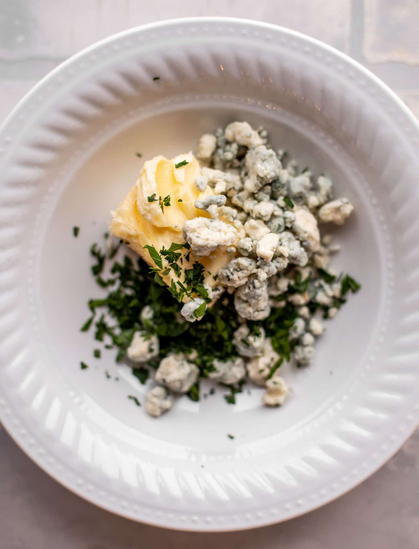 butter, herbs, blue cheese in a bowl