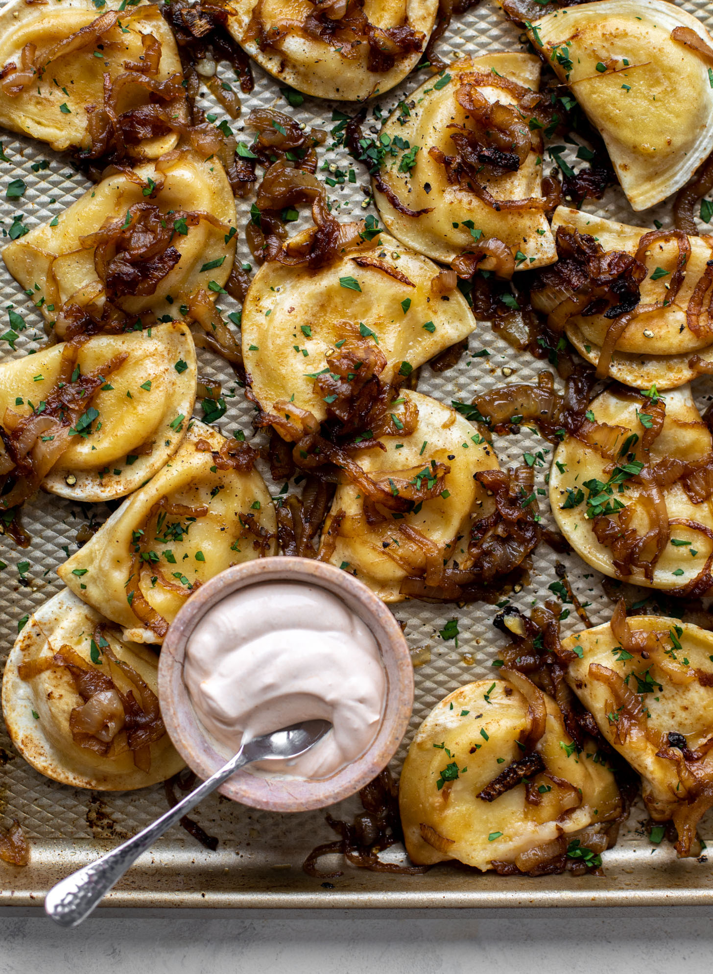 sheet pan pierogies with caramelized onions and chipotle sour cream
