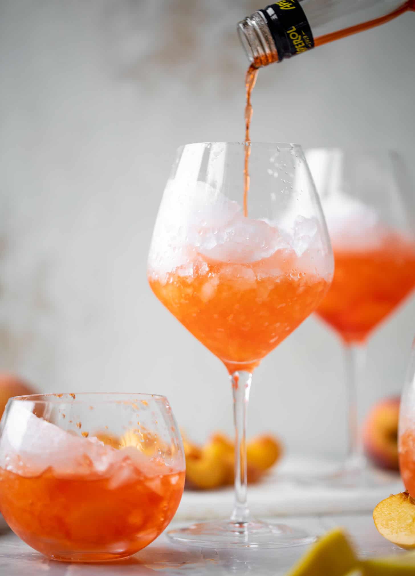 pouring aperol over crushed ice