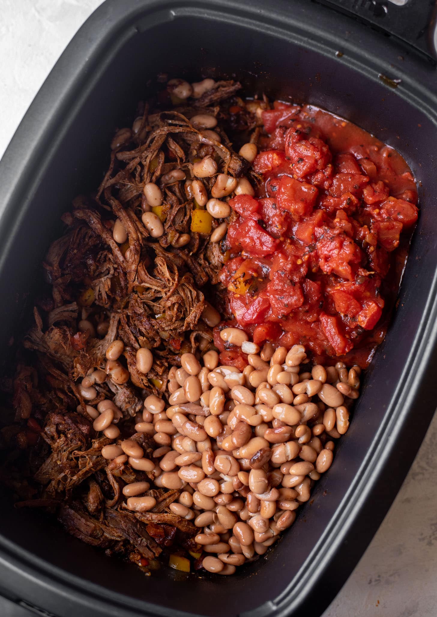 slow cooker with brisket, fire roasted tomatoes and pinto beans