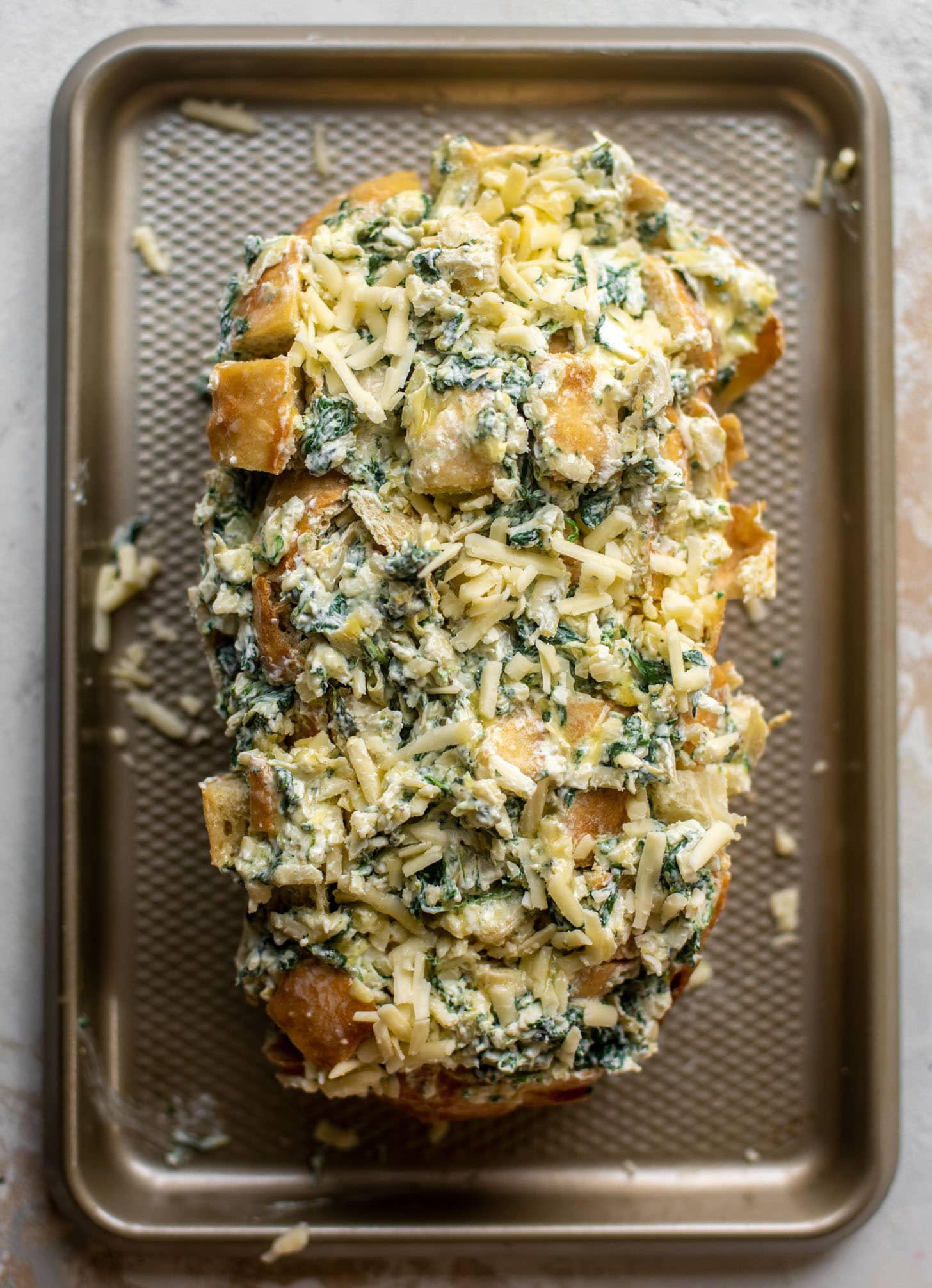 bread sliced and stuffed with spinach artichoke dip
