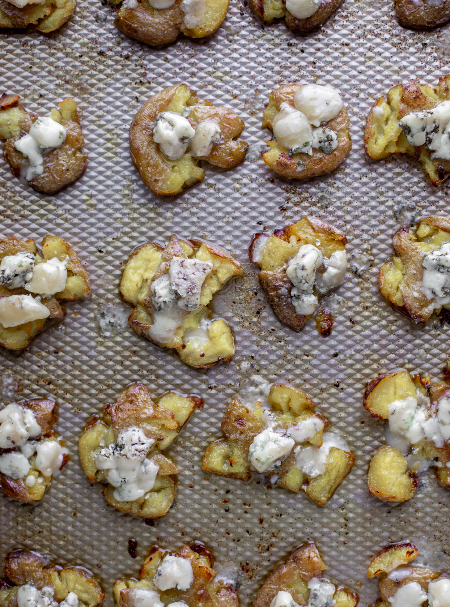 smashed potatoes on baking sheet with blue cheese