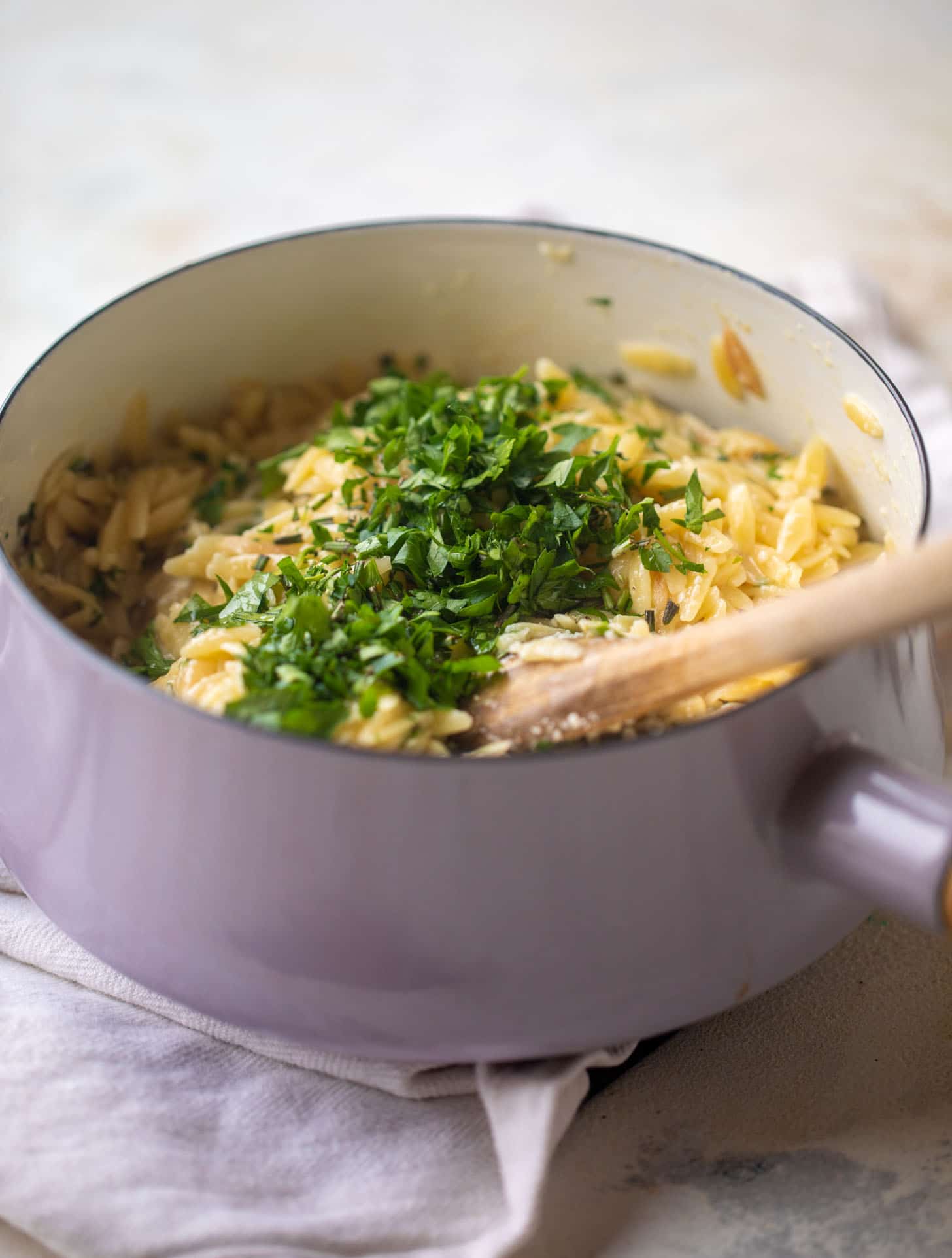 cooked orzo in a pot with fresh herbs