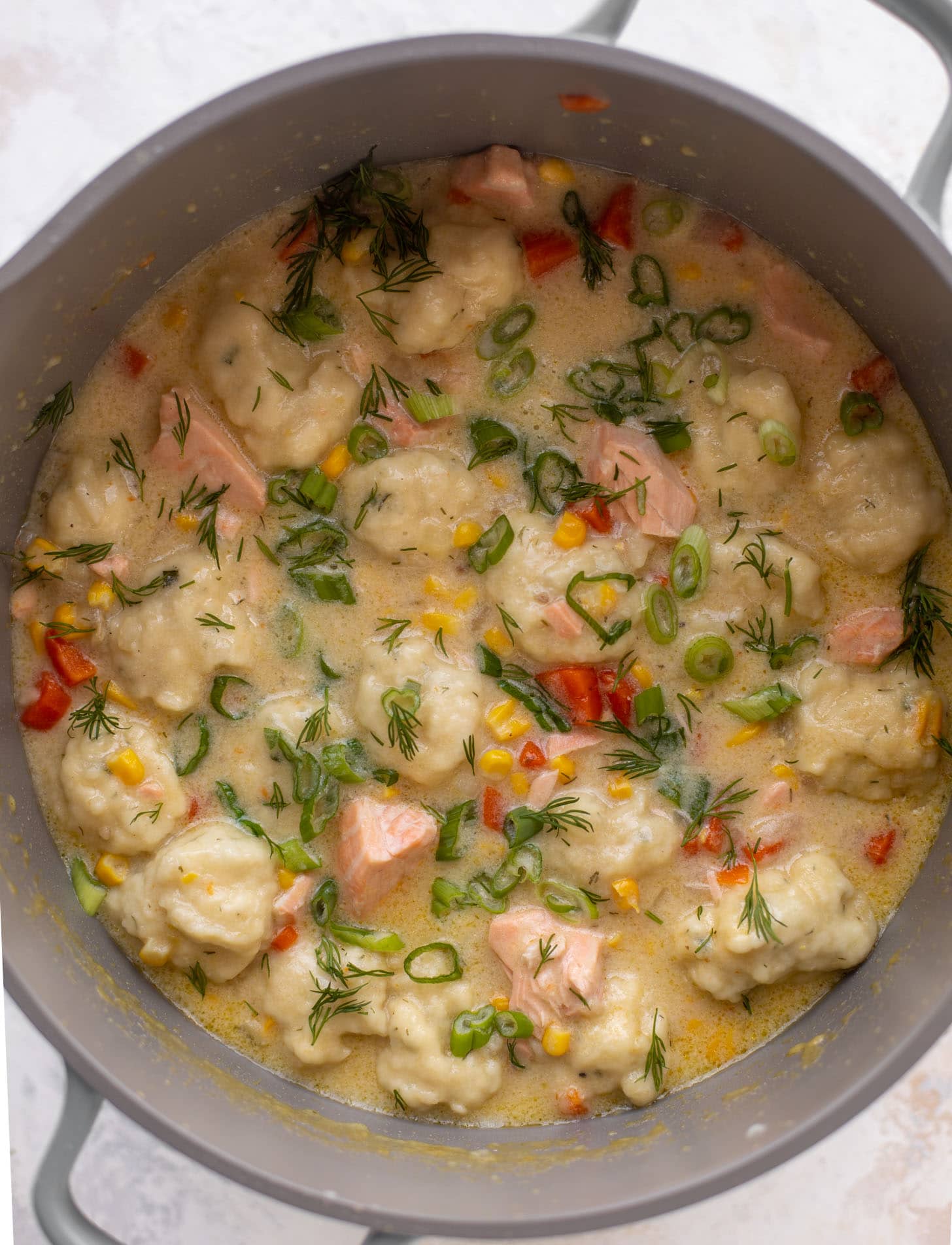 salmon chowder with dill dumplings in a pot