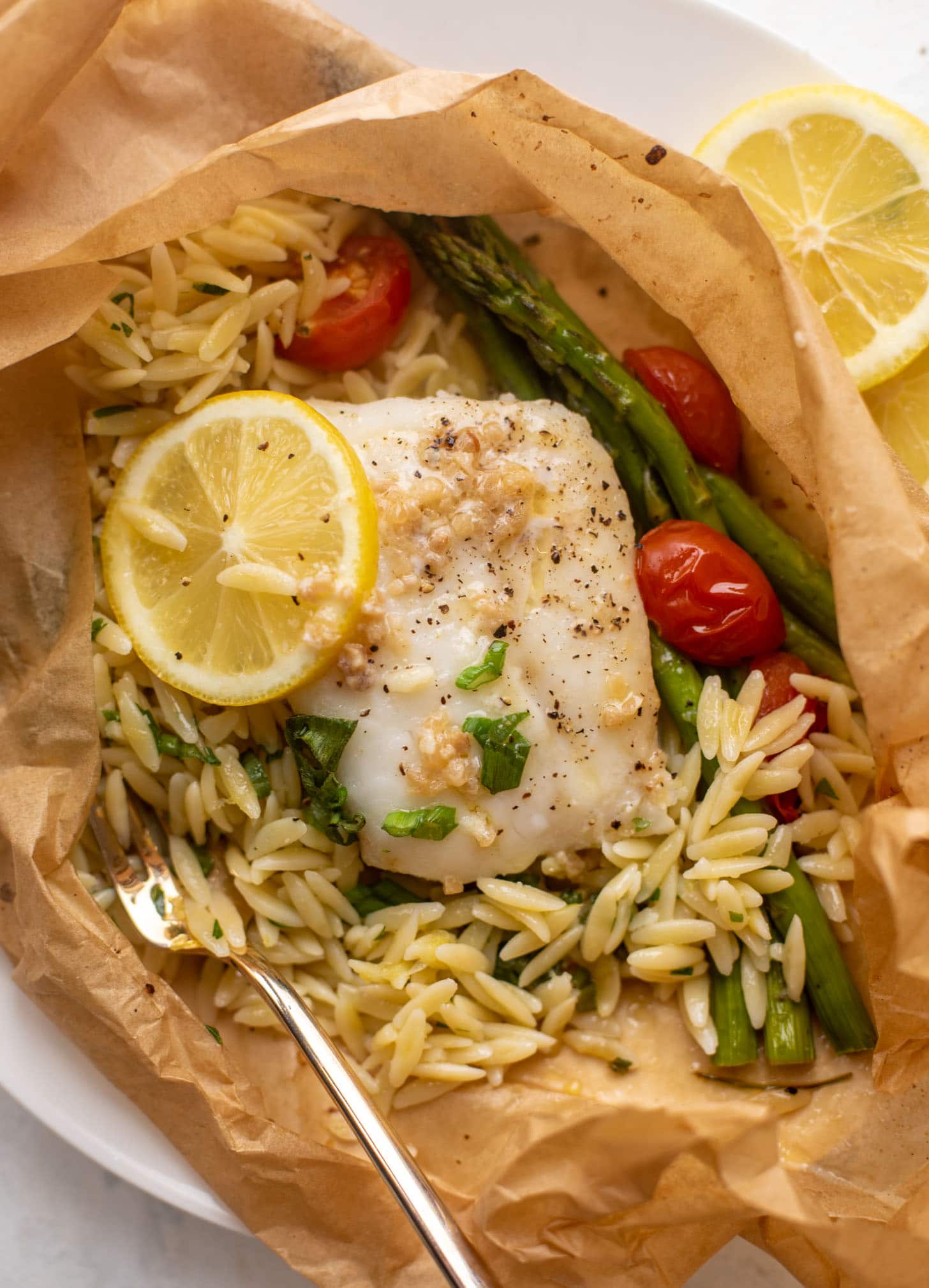 lemon garlic butter orzo and fish in parchment packet