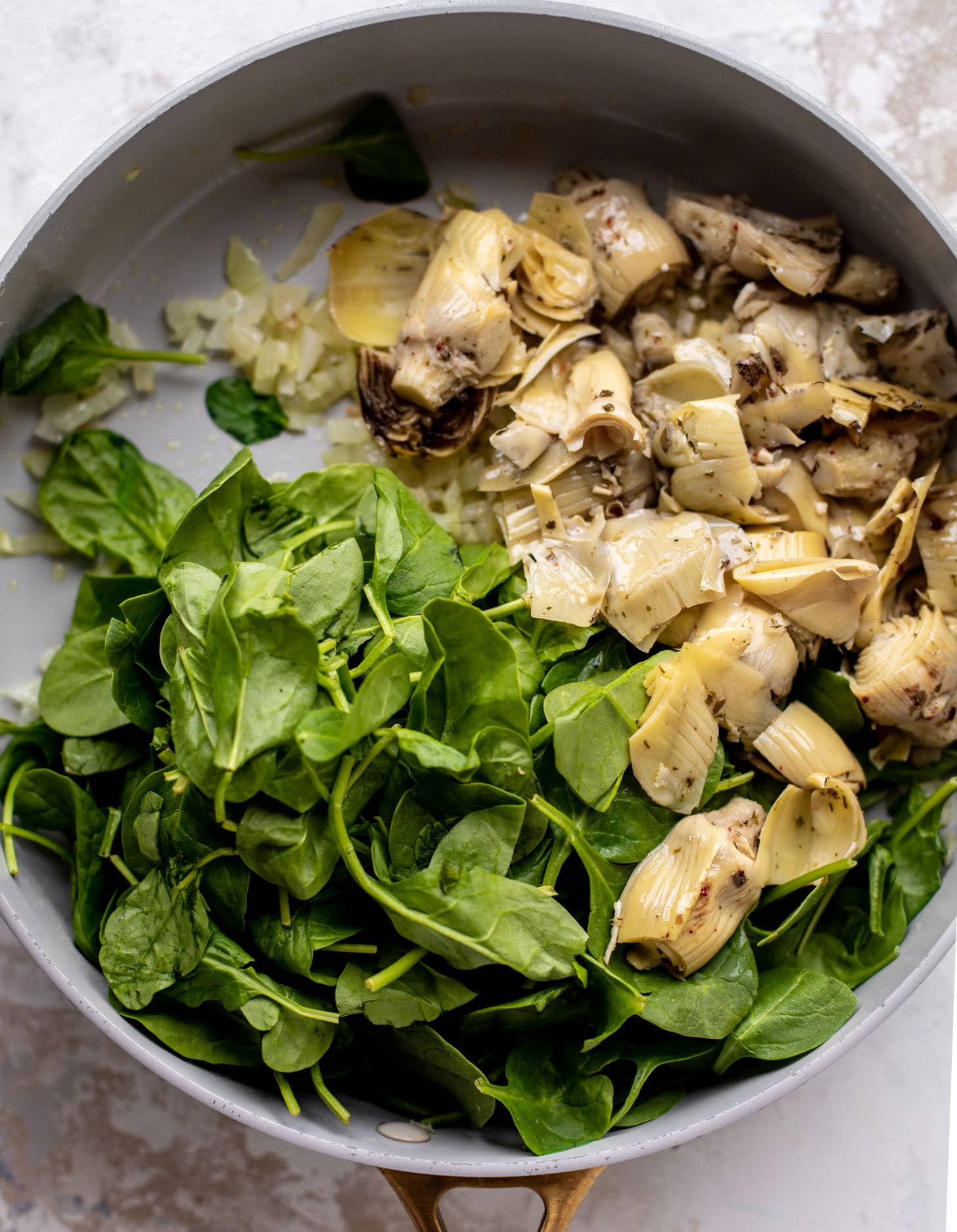 spinach and artichokes in a skillet