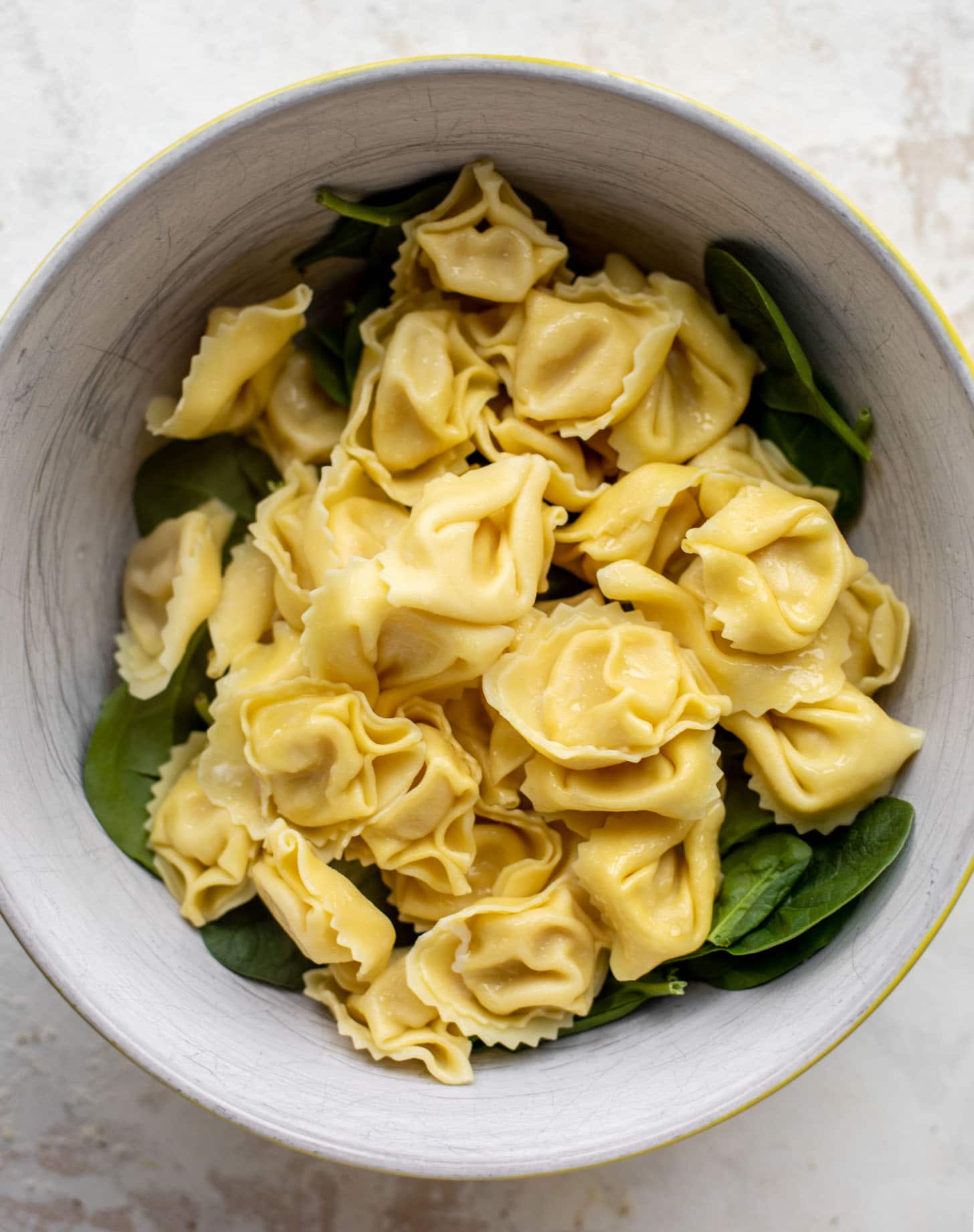 baby spinach and tortellini in a bowl