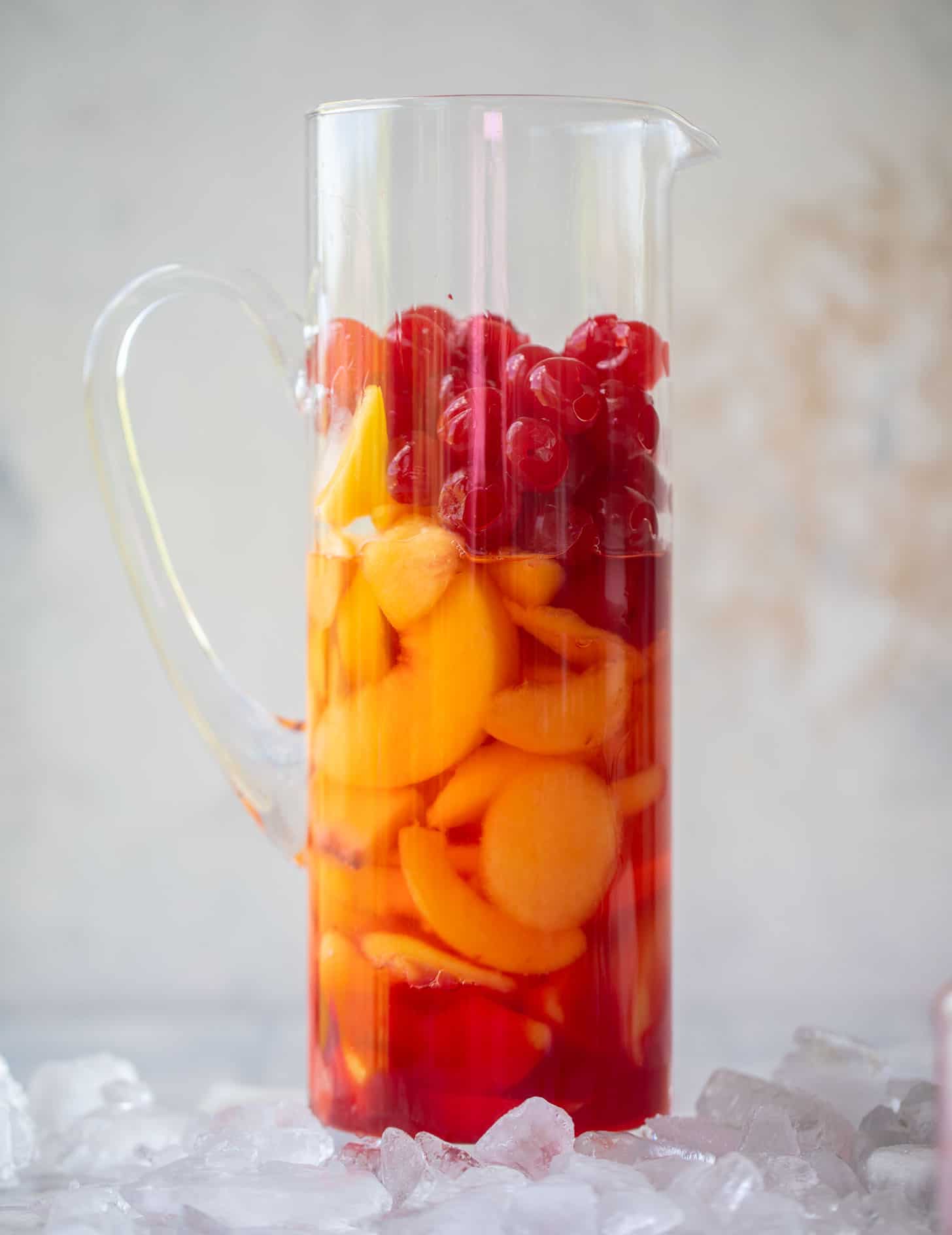 peaches and cherries in a pitcher