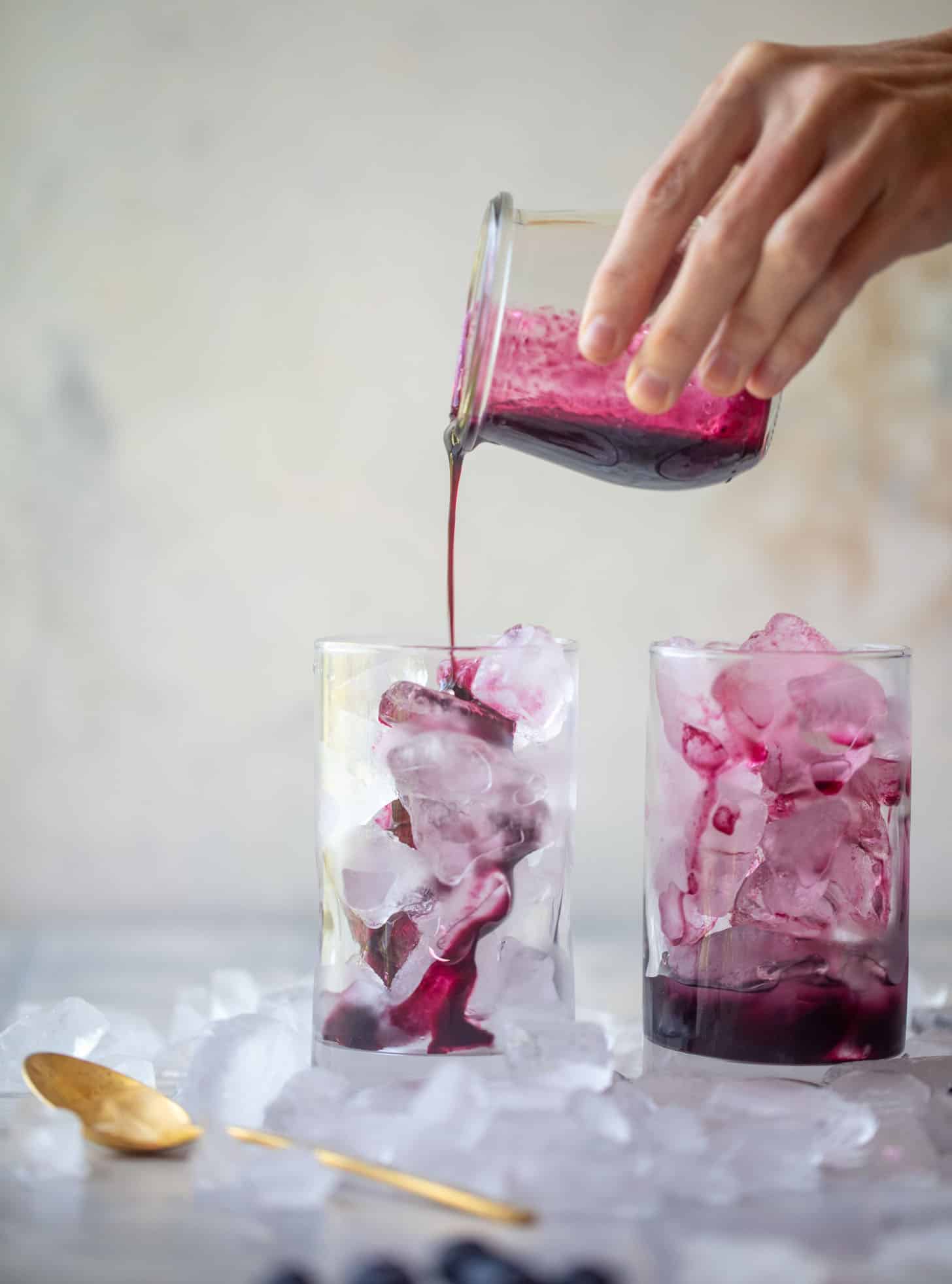pouring blueberry lavender syrup over ice